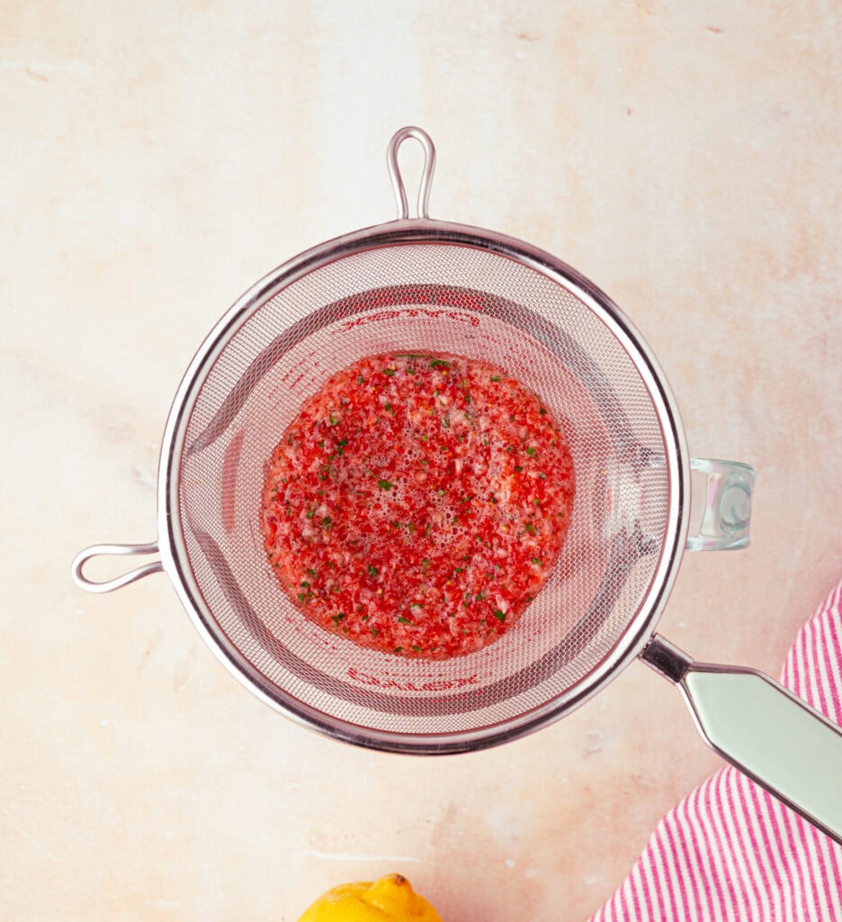 straining homemade strawberry basil lemonade