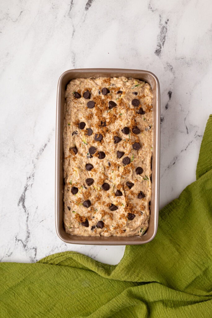 topping sourdough zucchini bread with chocolate chips and maple sugar