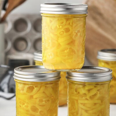 Glass jars filled with homemade and shelf-stable pickled banana pepper rings.